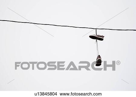 Picture - Shoes hanging in power line. Fotosearch