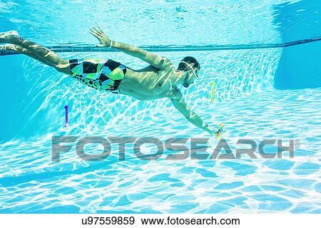 Side-view of young man swimming in pool View Large Photo Image Stock Photo - Side-view of young man swimming in pool. Fotosearch