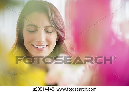 Smiling woman behind blurred flowers View Large Photo Image Stock Photo - Smiling woman behind blurred flowers. Fotosearch