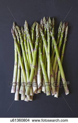 Stack of asparagus on black background View Large Photo Image Picture - Stack of asparagus on black background. Fotosearch