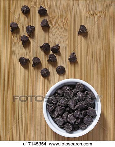 Picture - Stack of chocolate chips in ramekin. Fotosearch