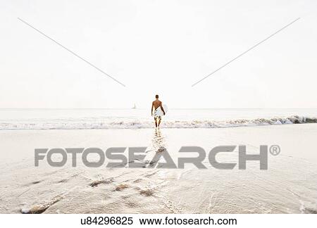 Stock Photography - Surfer looking at sailboat. Fotosearch