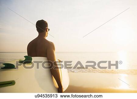 Surfer looking at sunset View Large Photo Image Stock Image - Surfer looking at sunset. Fotosearch