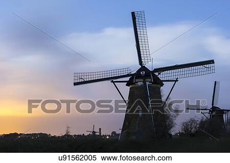 View of windmills at sunset View Large Photo Image Stock Photography - View of windmills at sunset. Fotosearch