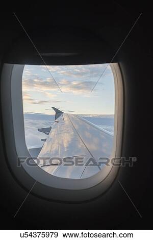 Wing of airplane seen through airplane window View Large Photo Image Stock Photo - Wing of airplane seen through airplane window. Fotosearch