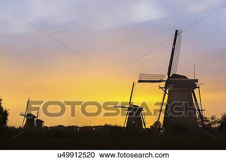 Winmills silhouetted against sunset sky View Large Photo Image Stock Image - Winmills silhouetted against sunset sky. Fotosearch