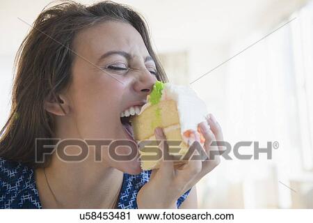 Woman biting piece of cake View Large Photo Image Stock Image - Woman biting piece of cake. Fotosearch
