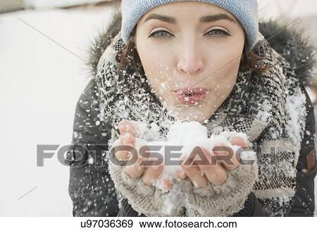 Stock Photo - Woman blowing snow towards camera. Fotosearch