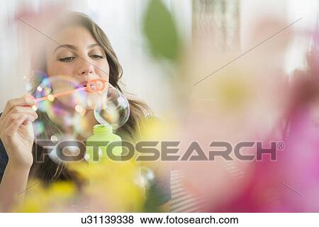 Stock Photo - Woman blowing soap bubbles. Fotosearch