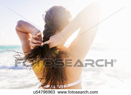 Woman braiding her hair on beach View Large Photo Image Stock Image - Woman braiding her hair on beach. Fotosearch