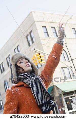 Stock Image - Woman calling taxi in winter. Fotosearch
