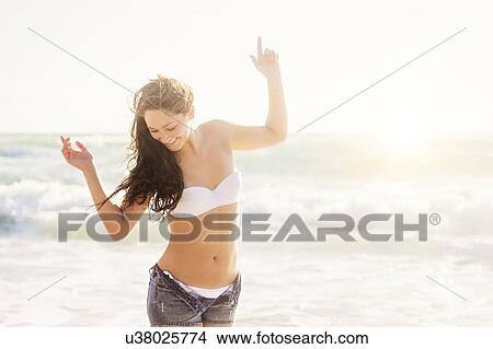 Picture - Woman dancing on beach. Fotosearch