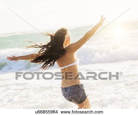 Picture - Woman having fun on beach. Fotosearch