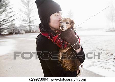 Woman holding and kissing dog View Large Photo Image Picture - Woman holding and kissing dog. Fotosearch