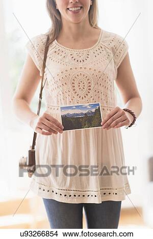 Picture - Woman holding antique camera and pictures. Fotosearch