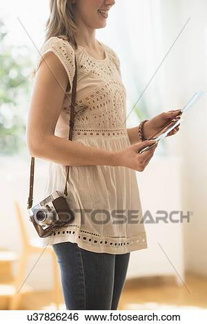 Stock Photograph - Woman holding antique camera and pictures. Fotosearch