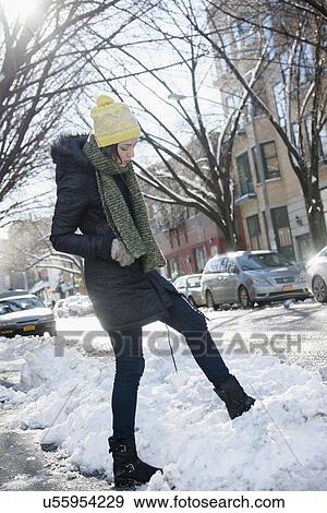 Woman in street putting her leg into snow View Large Photo Image Stock Photo - Woman in street putting her leg into snow. Fotosearch