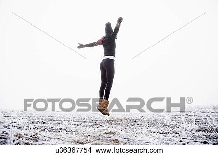 Picture - Woman jumping outdoors. Fotosearch