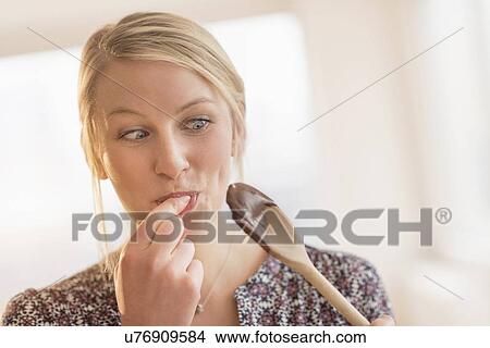 Woman licking batter off spoon View Large Photo Image Picture - Woman licking batter off spoon. Fotosearch