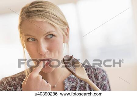 Woman licking batter off spoon View Large Photo Image Stock Photograph - Woman licking batter off spoon. Fotosearch