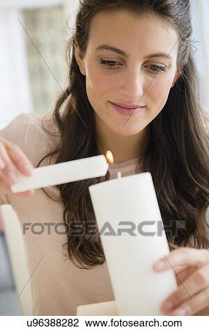 Woman lighting candle View Large Photo Image Stock Image - Woman lighting candle. Fotosearch