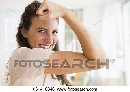 Stock Photograph - Woman making a muscle. Fotosearch
