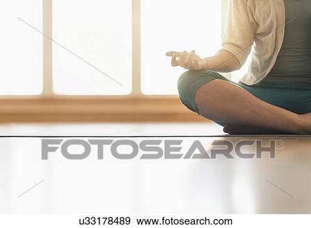 Stock Photo - Woman meditating on floor. Fotosearch