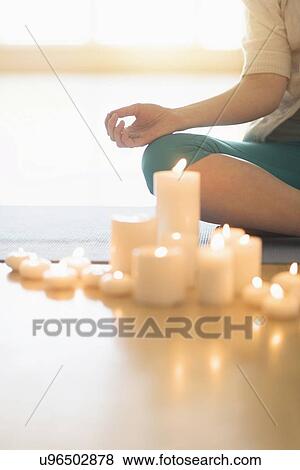 Woman meditating surrounded by candles View Large Photo Image Stock Photo - Woman meditating surrounded by candles. Fotosearch