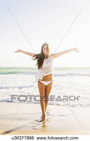 Woman on beach with arms raised View Large Photo Image Stock Photo - Woman on beach with arms raised. Fotosearch