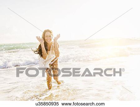 Woman on beach with arms raised View Large Photo Image Stock Photography - Woman on beach with arms raised. Fotosearch