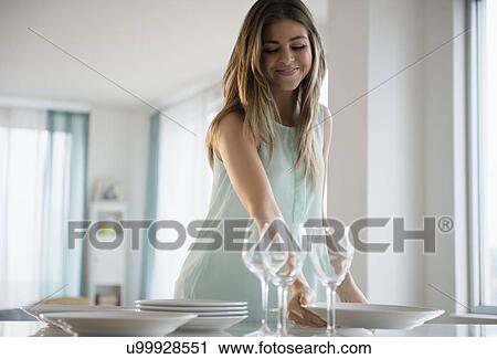 Woman putting plates on table View Large Photo Image Stock Image - Woman putting plates on table. Fotosearch