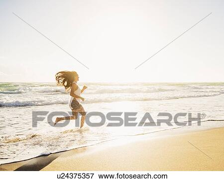 Woman running in water View Large Photo Image Stock Photo - Woman running in water. Fotosearch