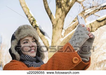 Woman taking selfie outdoors in winter View Large Photo Image Stock Photography - Woman taking selfie outdoors in winter. Fotosearch
