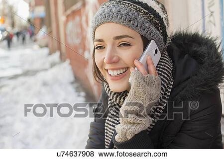 Stock Photo - Woman talking on phone in winter street. Fotosearch