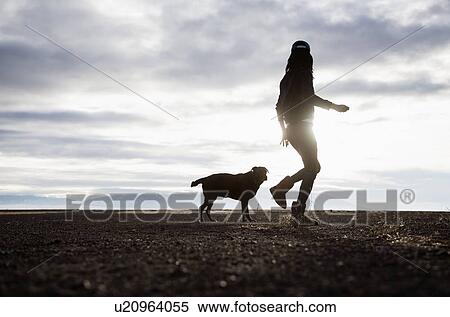 Woman walking with dog at sunrise View Large Photo Image Stock Photography - Woman walking with dog at sunrise. Fotosearch
