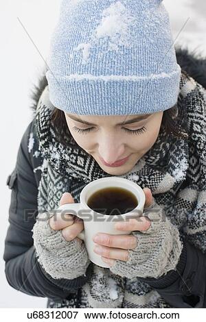 Stock Photo - Woman with coffee mug in snow. Fotosearch