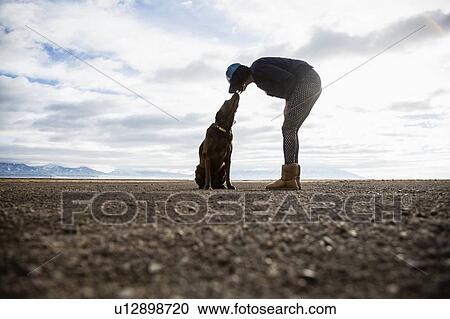 Stock Image - Woman with dog outdoors. Fotosearch