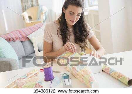 Stock Image - Woman wrapping present. Fotosearch