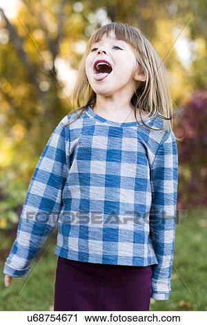 Young girl (4-5) with sticking out tongue View Large Photo Image Stock Image - Young girl (4-5) with sticking out tongue. Fotosearch