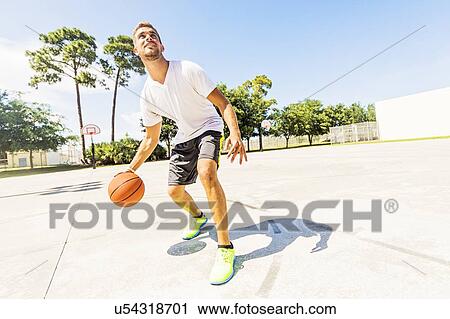Young man dribbling basketball View Large Photo Image Stock Image - Young man dribbling basketball. Fotosearch