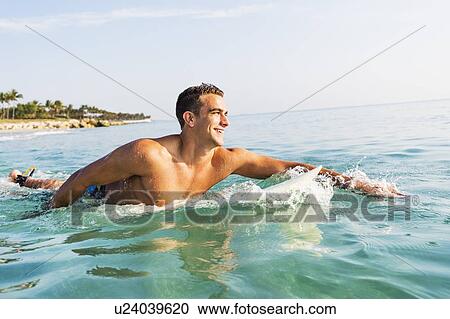 Young surfer paddling View Large Photo Image Stock Image - Young surfer paddling. Fotosearch