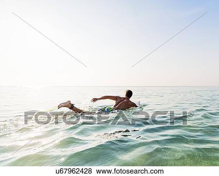 Young surfer paddling View Large Photo Image Stock Photo - Young surfer paddling. Fotosearch