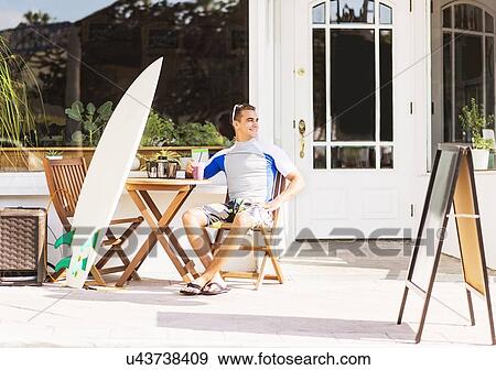 Young surfer sitting with smoothie View Large Photo Image Stock Photo - Young surfer sitting with smoothie. Fotosearch