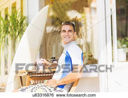 Stock Photograph - Young surfer sitting with smoothie. Fotosearch