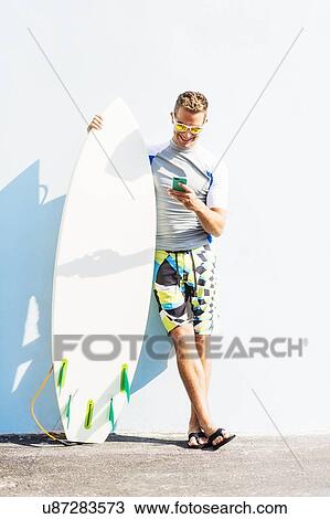 Young surfer texting View Large Photo Image Stock Image - Young surfer texting. Fotosearch