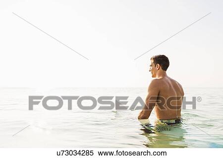 Young surfer watching waves View Large Photo Image Stock Photography - Young surfer watching waves. Fotosearch