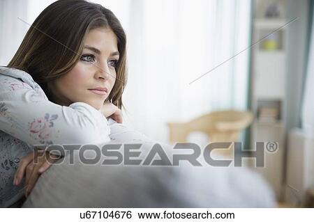 Young woman contemplating in living room View Large Photo Image Stock Photograph - Young woman contemplating in living room. Fotosearch