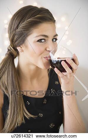 Stock Image - Young woman drinking red wine. Fotosearch