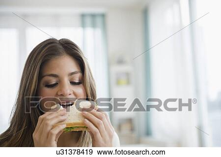 Young woman eating sandwich View Large Photo Image Stock Photo - Young woman eating sandwich. Fotosearch