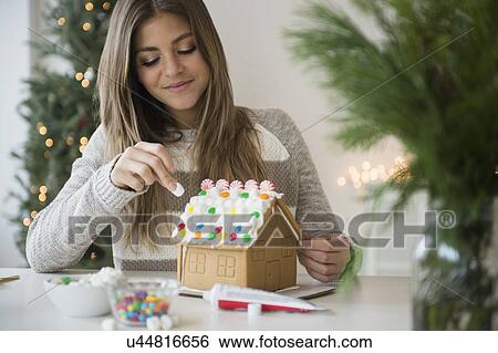 Young woman preparing gingerbread house View Large Photo Image Stock Photograph - Young woman preparing gingerbread house. Fotosearch